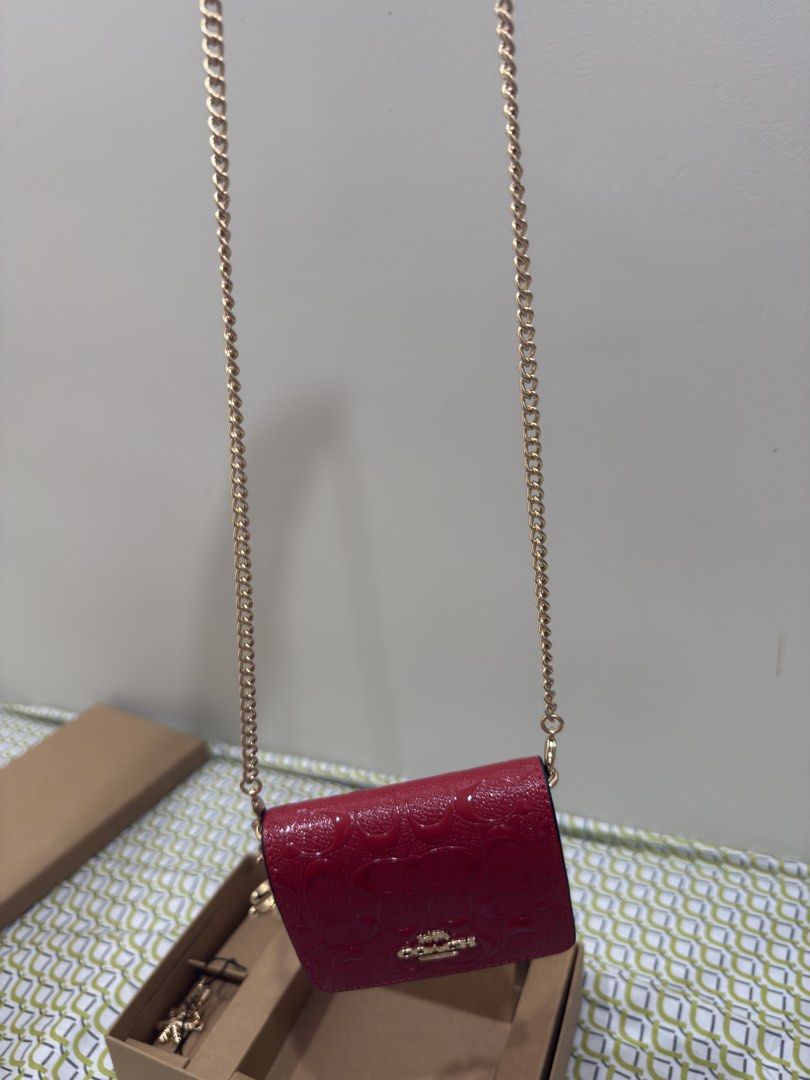 Coach Red Monogrammed Patent Leather Wallet with Chain (Category: Wallets & Card holders) located in Palayan City. Submitted by leira213 (Listing ID 1463329505, Image 1). Description: - Authentic Red Coach wallet - Signature monogram pattern - Patent leather finish - Detachable gold chain strap - Interior card slots - Comes with original box - Ideal for carrying essentials.
