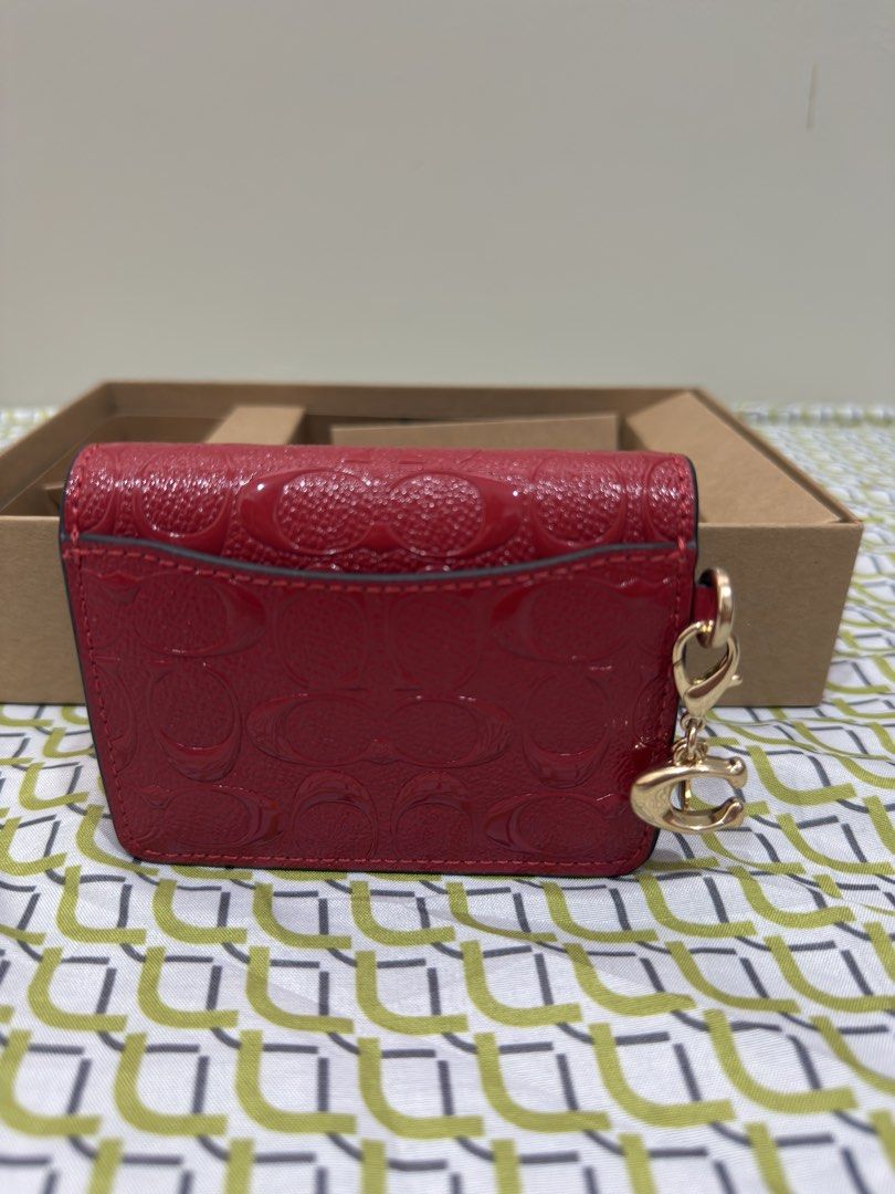 Coach Red Monogrammed Patent Leather Wallet with Chain (Category: Wallets & Card holders) located in Palayan City. Submitted by leira213 (Listing ID 1463329505, Image 3). Description: - Authentic Red Coach wallet - Signature monogram pattern - Patent leather finish - Detachable gold chain strap - Interior card slots - Comes with original box - Ideal for carrying essentials.