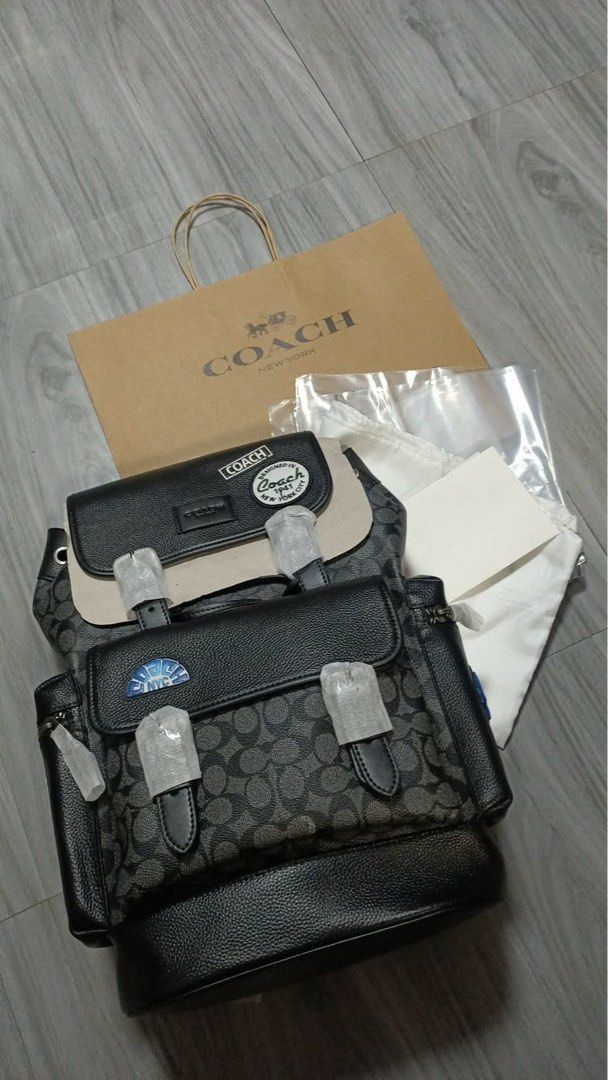 Coach Signature Backpack with Patches (Category: Backpacks) located in Manila. Submitted by yeshuajohn80056 (Listing ID 1463456884, Image 1). Description: - Authentic Coach backpack in signature print - Features two front pockets and decorative patches - Comes with original dust bag and shopping bag - Straps are still wrapped in protective plastic - Ideal for everyday use or travel.