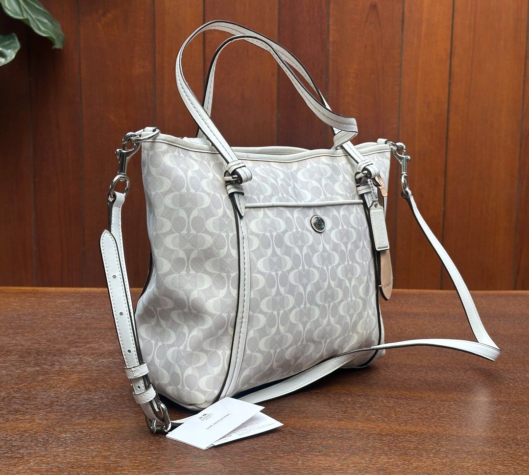 Coach Signature Tote Bag 🤍 (Category: Shoulder Bags) located in Bulacan. Submitted by thriftbagcollections (Listing ID 1463390573, Image 3). Description: Coach Signature Tote Bag 🤍 Elegant white and gray signature print, with top handles and a detachable shoulder strap. Spacious and perfect for everyday use.Good condition!Approx:H-11”W-15”D-4.5”.