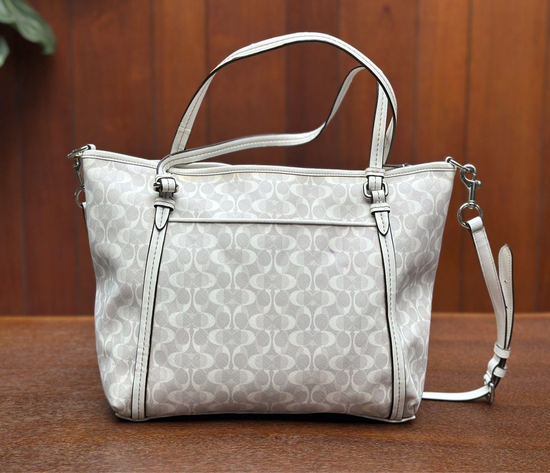 Coach Signature Tote Bag 🤍 (Category: Shoulder Bags) located in Bulacan. Submitted by thriftbagcollections (Listing ID 1463390573, Image 2). Description: Coach Signature Tote Bag 🤍 Elegant white and gray signature print, with top handles and a detachable shoulder strap. Spacious and perfect for everyday use.Good condition!Approx:H-11”W-15”D-4.5”.
