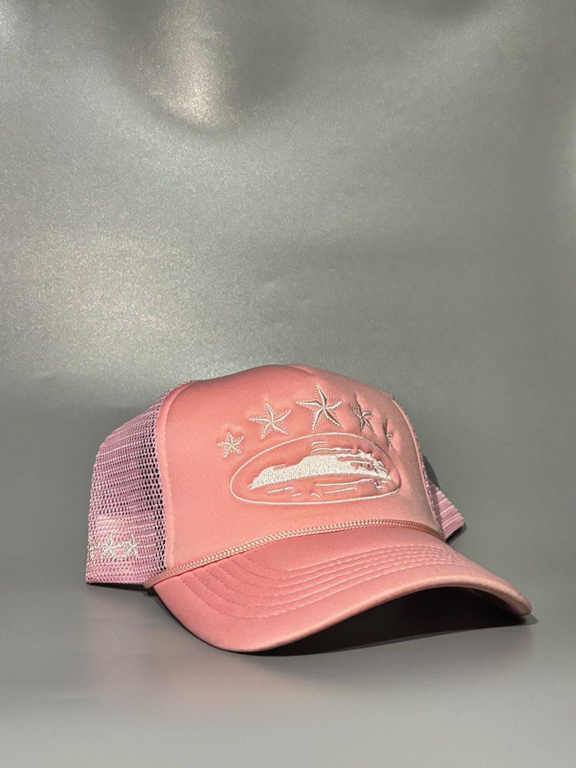 Corteiz Pink Trucker Hat with Embroidered Design (Category: Caps & Hats) located in Manila. Submitted by gilmorecapz (Listing ID 1463441743, Image 1). Description: - Pink Corteiz trucker hat - Embroidered front design: stars and wave/boat graphic - Mesh back for breathability - Adjustable snap closure for a custom fit - Features Corteiz branding inside - Ideal for casual wear.