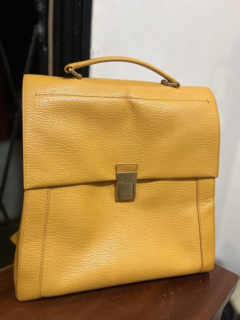 Couronne Yellow Leather Backpack (Category: Backpacks) located in Bacolod City. Submitted by vintage_vogue6100 (Listing ID 1463372944, Image 1). Description: - Brand: Couronne - Color: Yellow - Material: Leather - Features: Top handle, adjustable backpack straps, gold buckle front closure - Interior: Multiple pockets for organization - Ideal for: Everyday use, travel.