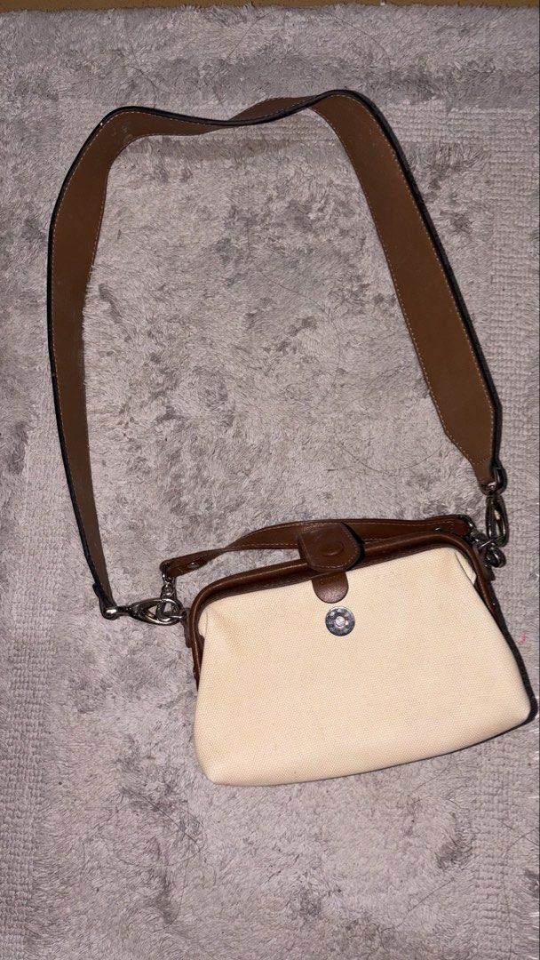 Cream and Brown Canvas Handbag with Leather Strap (Category: Tote Bags) located in Manila. Submitted by keenfox-84bb (Listing ID 1463381707, Image 1). Description: - Cream canvas handbag with brown leather accents - Adjustable and detachable strap - Secure button closure on front flap - Small silver hardware detail - Ideal for everyday use, fits your essentials never been used na stock lang .