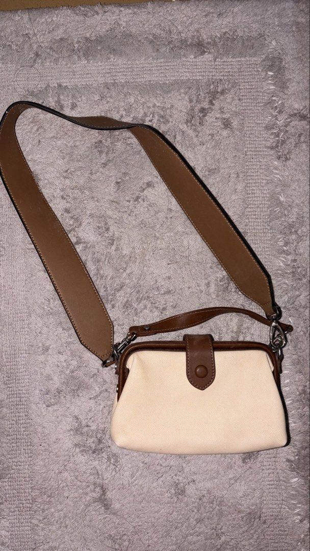 Cream and Brown Canvas Handbag with Leather Strap (Category: Tote Bags) located in Manila. Submitted by keenfox-84bb (Listing ID 1463381707, Image 2). Description: - Cream canvas handbag with brown leather accents - Adjustable and detachable strap - Secure button closure on front flap - Small silver hardware detail - Ideal for everyday use, fits your essentials never been used na stock lang .