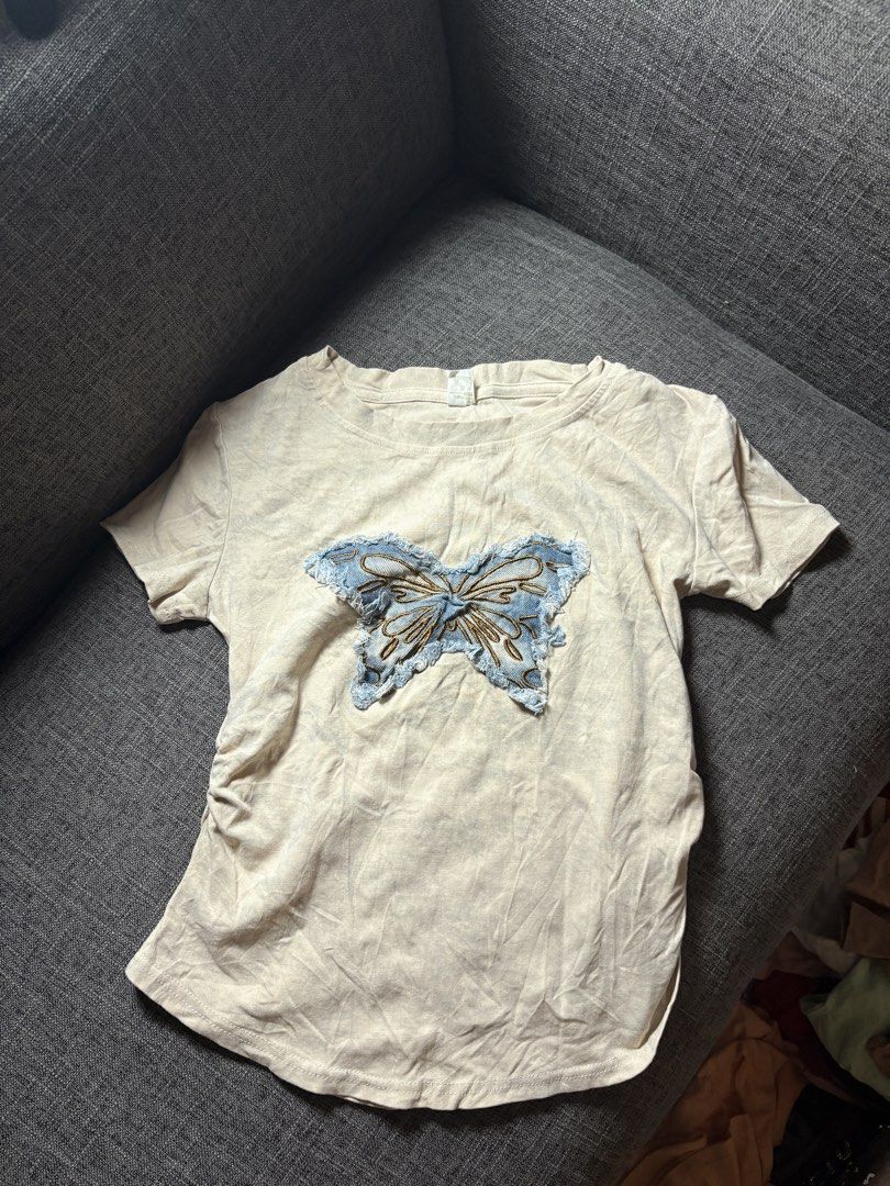 Cream Butterfly Patch T-shirt (Category: Blouses) located in Malolos. Submitted by deffnotandwie (Listing ID 1463384125, Image 2). Description: - Blue denim butterfly patch with brown stitching details on the front - Ruched sides for a flattering fit - Short sleeves - Casual and cute top Thrift Korean Tees small to med.
