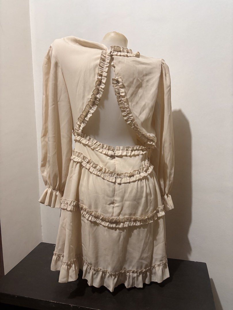 Cream Ruffled Tiered Open Back Mini Dress (Category: Dresses) located in Manila. Submitted by youngstorm-2021 (Listing ID 1463358279, Image 1). Description: - used only once - Cream colored mini dress - Long sleeves with ruffled cuffs - V-neckline with ruffled trim - Tiered skirt with ruffles - Open back with ruffled edges - Button closure at back neck and waist - Fun and flirty style.