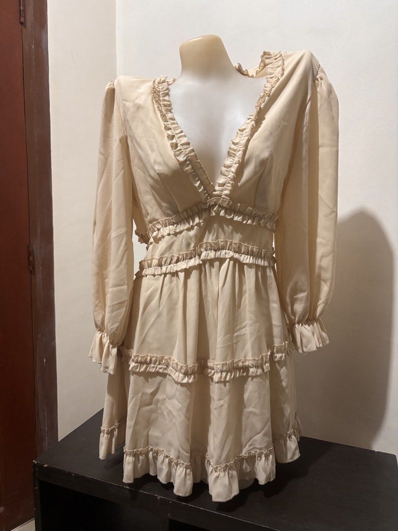 Cream Ruffled Tiered Open Back Mini Dress (Category: Dresses) located in Manila. Submitted by youngstorm-2021 (Listing ID 1463358279, Image 2). Description: - used only once - Cream colored mini dress - Long sleeves with ruffled cuffs - V-neckline with ruffled trim - Tiered skirt with ruffles - Open back with ruffled edges - Button closure at back neck and waist - Fun and flirty style.