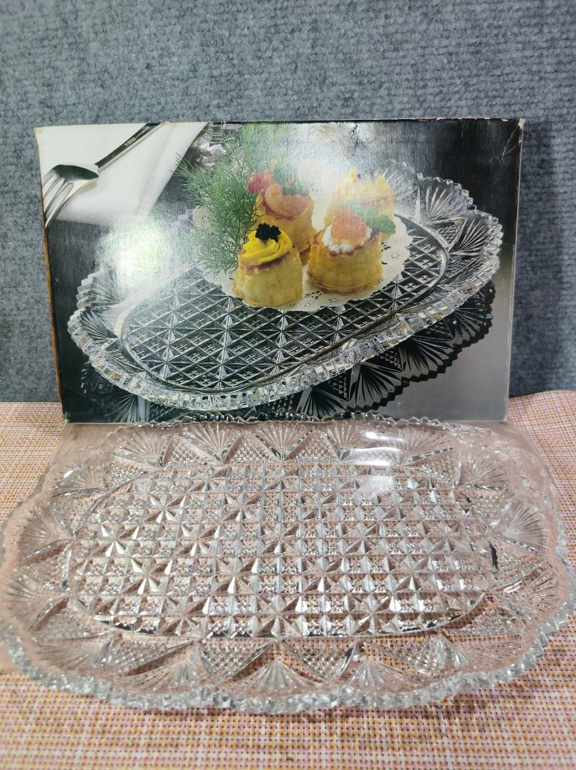 Crystal Glass Serving Platter with Ornate Edge (Category: Dinnerware & Cutlery) located in San Leonardo. Submitted by burgossanleonardo.12345 (Listing ID 1463457620, Image 1). Description: - Elegant crystal glass serving platter - Features a detailed diamond pattern all over - Ornate, scalloped edges add a touch of sophistication - Ideal for serving appetizers, desserts, or small bites - Includes original box - 31 cm in length, approximately 22 c