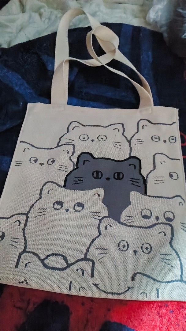 Cute Cat Print Tote Bag (Category: Tote Bags) located in Antipolo. Submitted by triplem_prelovedbags (Listing ID 1463358009, Image 1). Description: Canvas tote bag with a cute all-over cat print. Features a dark grey cat in the center surrounded by white cats. The straps are a light beige color. Great for everyday use, carrying books, or groceries. Simple and stylish design..
