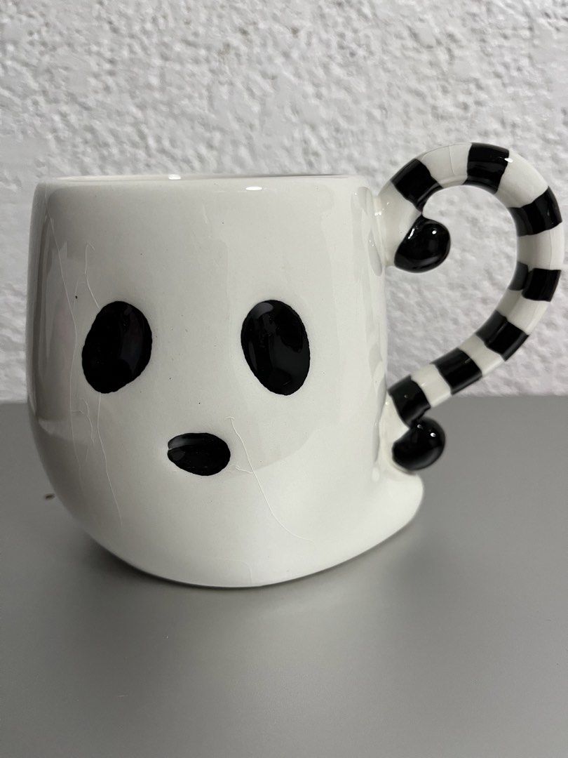 Cute Ghost Mug with Striped Handle (Category: Coffee & Tea Tableware) located in Mandaue City. Submitted by allthingzdopamine (Listing ID 1463373176, Image 1). Description: -White ghost mug with black eyes and mouth -Black and white striped handle -Features fine surface cracks -Perfect for Halloween or spooky enthusiasts -Great for your daily coffee or tea -has visible crazings at the back of the mug, but none on the inside .