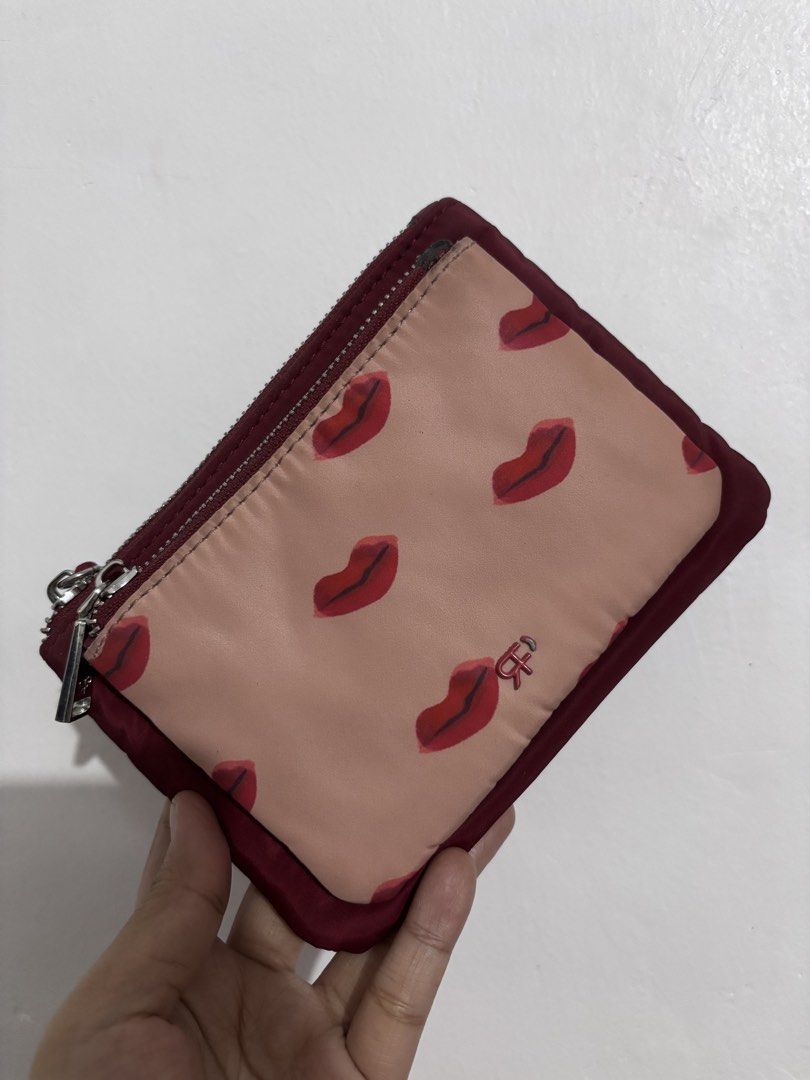 Cute Lips Pouch with Double Zippers (Category: Purses & Pouches) located in Manila. Submitted by fashionfinds21 (Listing ID 1463353032, Image 1). Description: - Small pouch with a fun lip print on one side. - Plain maroon on the other side. - Features two zippers for easy access. - Includes a cute rope pull on one zipper. - Perfect for organizing small essentials. - Shows some signs of wear on the edges of the zippers. .