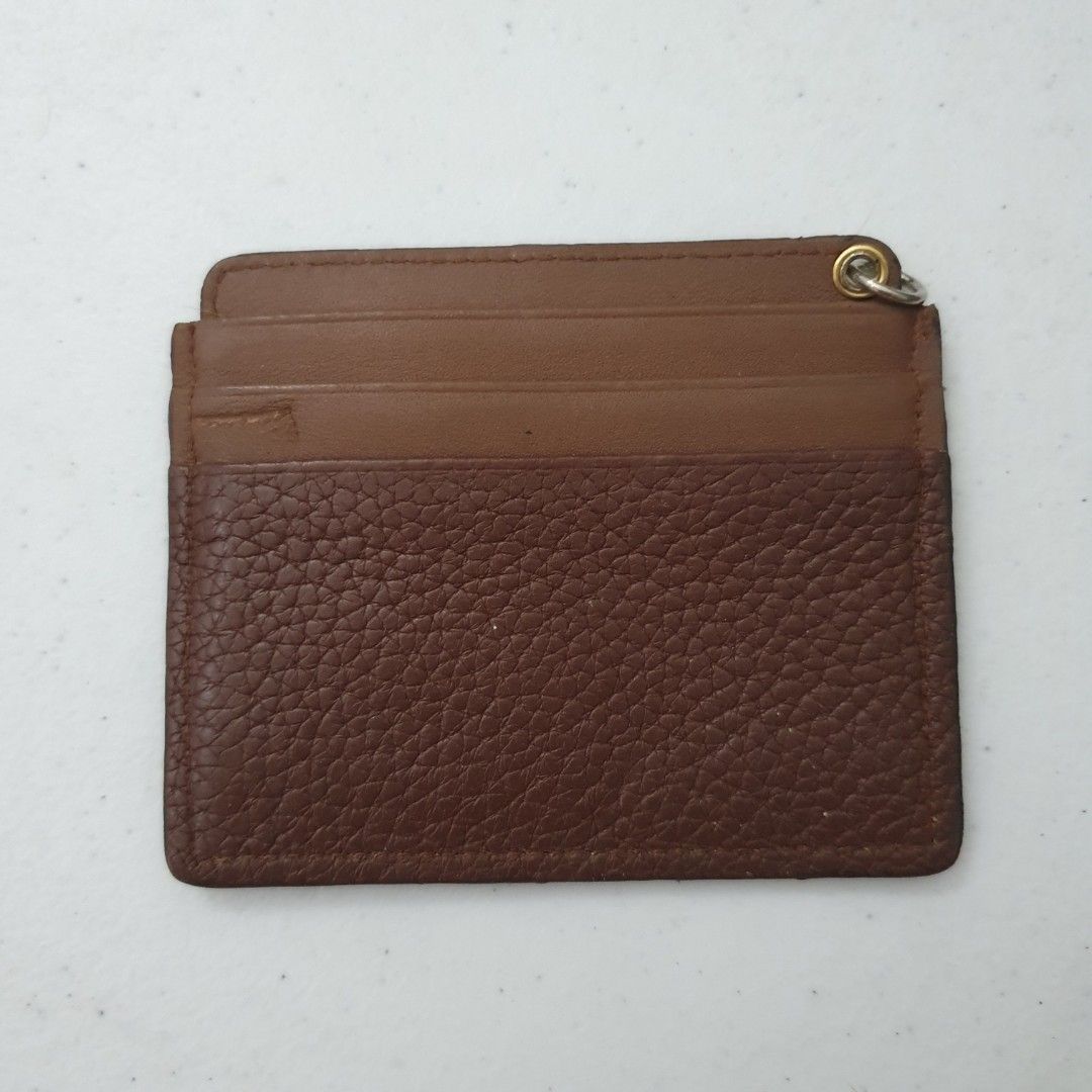Daks Brown Leather Card Holder (Category: Wallets & Card holders) located in Paranaque City. Submitted by cobien (Listing ID 1463449817, Image 2). Description: - Genuine brown leather card holder - Textured exterior for a sophisticated look - Multiple card slots for organized storage - Convenient small metal ring attached to the top corner - Compact size: 4 x 3.25 inches - Perfect for everyday essentials, blending style and functionality.