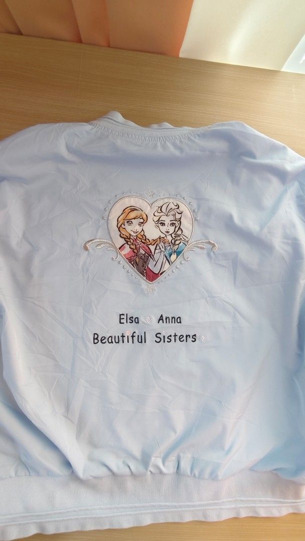 Disney Frozen Elsa & Anna Bomber Jacket (Category: Babies & Kids Fashion) located in Caloocan City. Submitted by luckybunny_8888 (Listing ID 1463346026, Image 2). Description: - Light blue bomber jacket featuring Disney's Frozen characters Elsa and Anna. - 'I LOVE ELSA' text detail on the sleeve. - 'Beautiful Sisters' text detail on the back. - Zip-up front closure. - Two functional pockets. - Ideal for any fan of the movie Frozen..