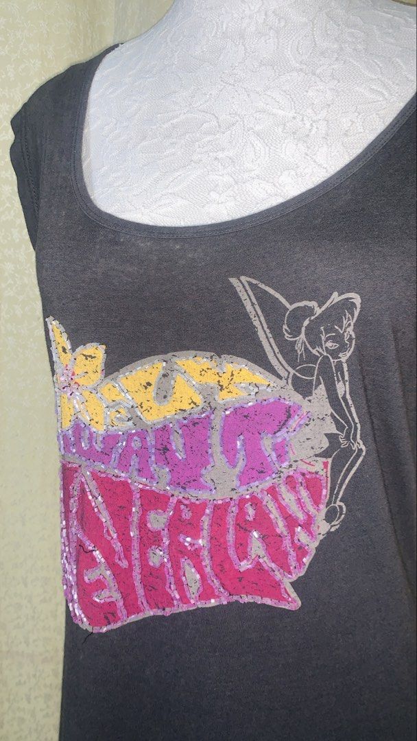 Disney Tinkerbell Graphic T-Shirt (Category: Shirts) located in Dagupan City. Submitted by sj_styles0910. (Listing ID 1463534140, Image 2). Description: - Dark grey t-shirt featuring a fun Tinkerbell graphic - Graphic includes colorful sequins and glitter details - Made from a soft rayon and cotton blend for comfort - Ideal for any Disney fan - Officially branded by Disney (check tag).