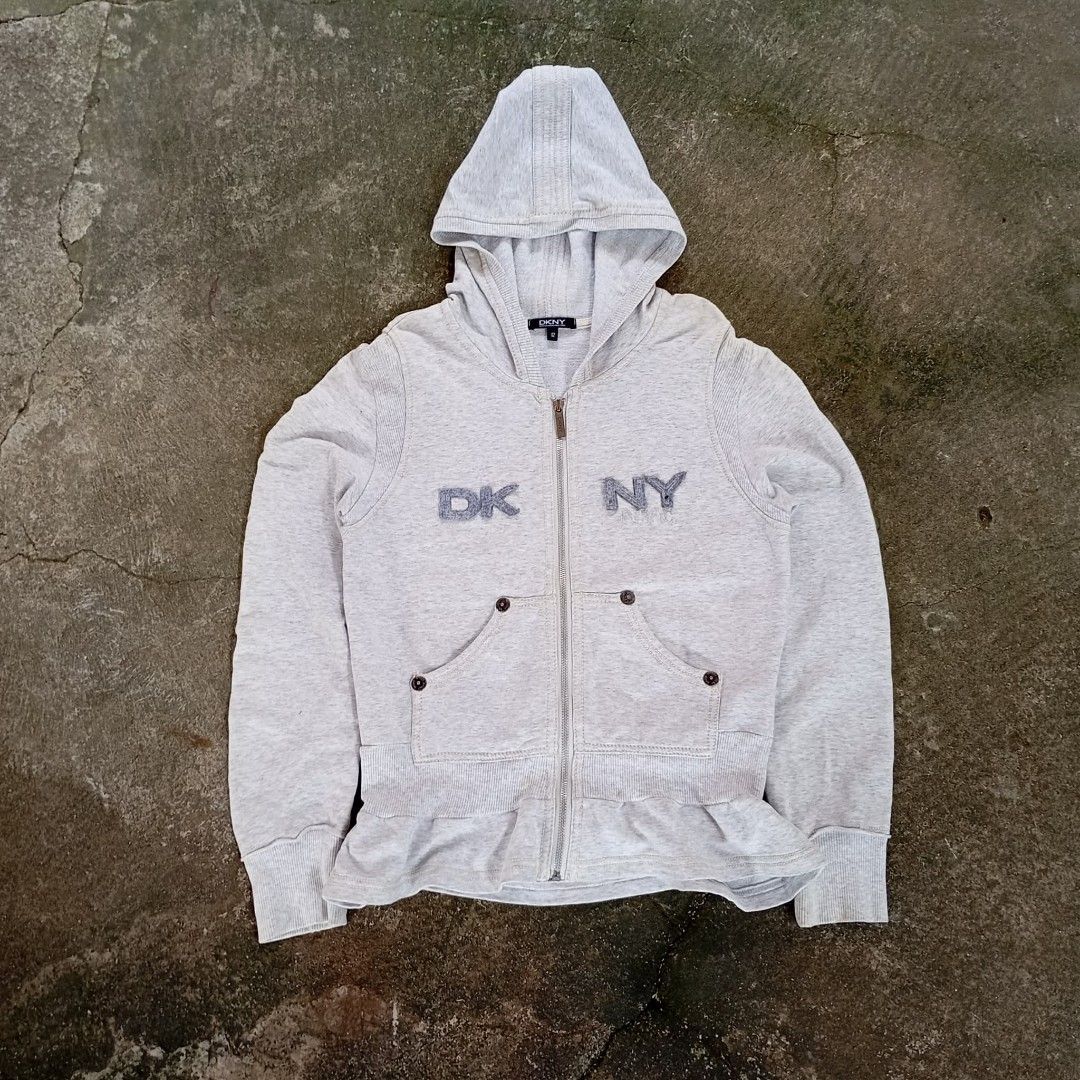 DKNY Grey Zip-Up Hoodie (Category: Coats, Jackets and Outerwear) located in Calamba. Submitted by doityourselfffff (Listing ID 1463547510, Image 1). Description: - Grey DKNY zip-up hoodie - DKNY logo on chest - Two front pockets with button details - Ruffled hemline - Made in China - Size 12 18 x 23 measurements excellent condition used.
