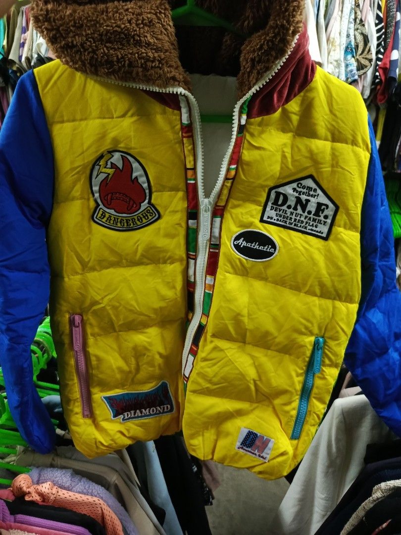 D.N.F. Dangerous Patchwork Puffer Jacket (Category: Coats, Jackets and Outerwear) located in Cabatuan. Submitted by penthegreat (Listing ID 1463462178, Image 2). Description: - Unique patchwork puffer jacket - Striking yellow and blue color block design - Features cool patches like 'Dangerous' and 'Diamond' - Green polka dot pattern on the back - Cozy fur-lined collar for extra warmth - Stand out with this eye-catching piece.