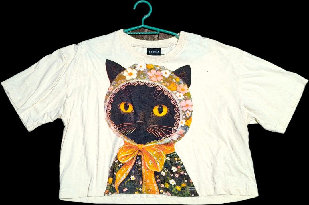 Goodly by Option semi crop top (Category: Tshirts & Polo Shirts ) located in Quezon City. Submitted by morningstar_52 (Listing ID 1463332762, Image 1). Description: - Cream colored t-shirt - Graphic print: Black cat wearing a floral bonnet and dress - Short sleeves - Brand: GOODLY by OPTION - Ideal for casual wear.