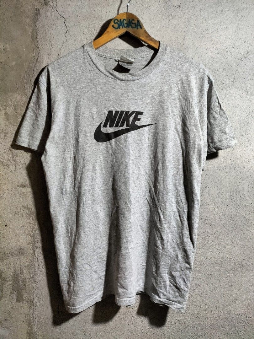 Grey Nike T-shirt Size M (Category: Tshirts & Polo Shirts ) located in Valencia. Submitted by cabisaythriftshop (Listing ID 1463419897, Image 1). Description: - Classic grey Nike t-shirt - Features the iconic Nike logo on the front - Made in Honduras from U.S.A. fabric - Size Medium - Great for everyday wear.