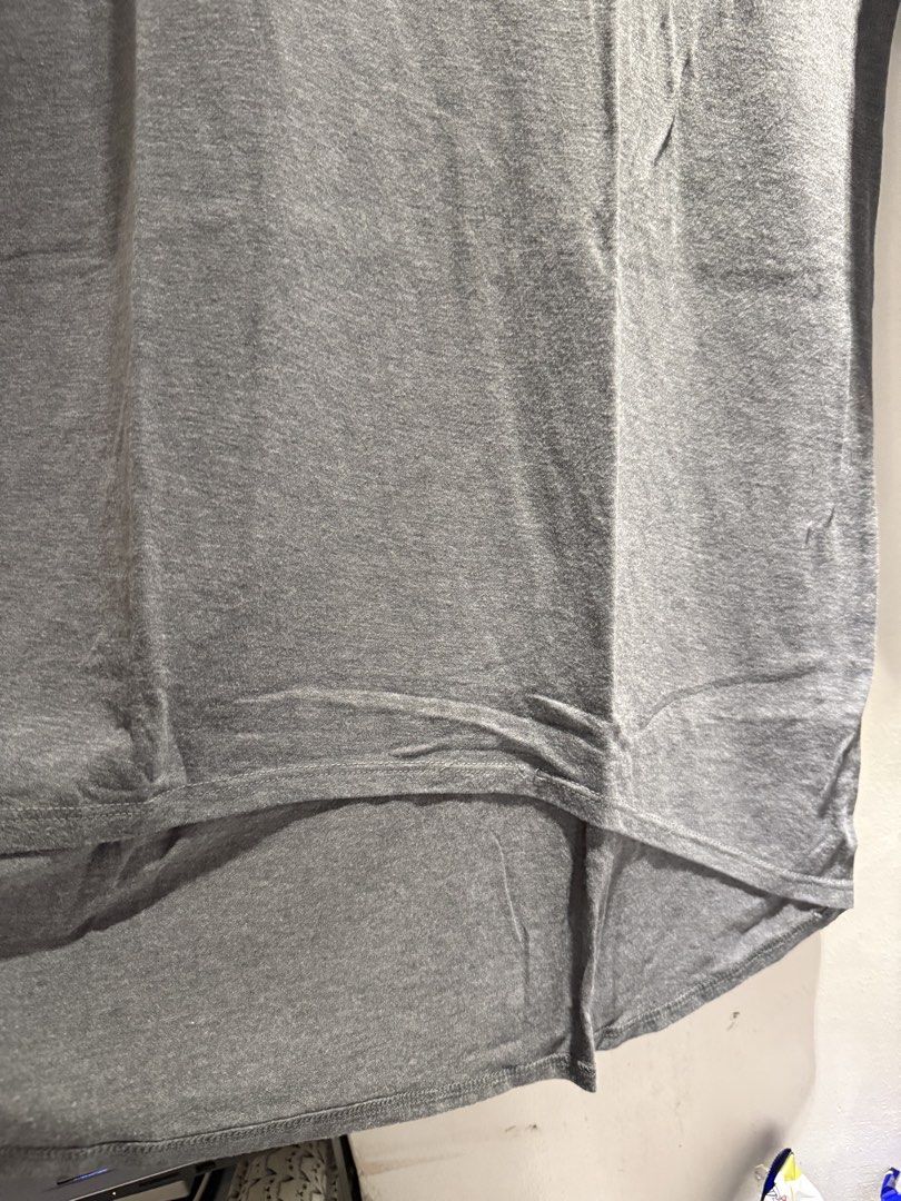 Grey T-shirt with Curved Hem (Category: Blouses) located in Manila. Submitted by jicka (Listing ID 1463328794, Image 3). Description: - Classic grey t-shirt - Short sleeves - Curved hemline, longer at the back - Simple and versatile design - Perfect for layering or wearing alone - Effortlessly matches any wardrobe - Bought for ₱200. Selling for ₱39.