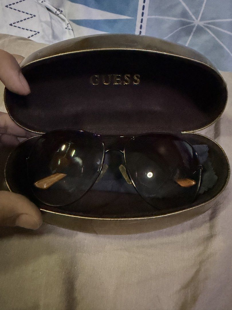 Guess Aviator Sunglasses with Case (Category: Sunglasses & Eyewear) located in Pasig City. Submitted by aprilluxcloset0812 (Listing ID 1463480278, Image 2). Description: - Guess aviator sunglasses - Dark lenses with subtle gradient - Arms with wood-like finish - Guess logo with heart-shaped accents on arms - Original hard case included RFS: decluttering EVERYTHING MUST GO‼️Just make a reasonable offer ❤️ All items ON HAND, handled with love, read