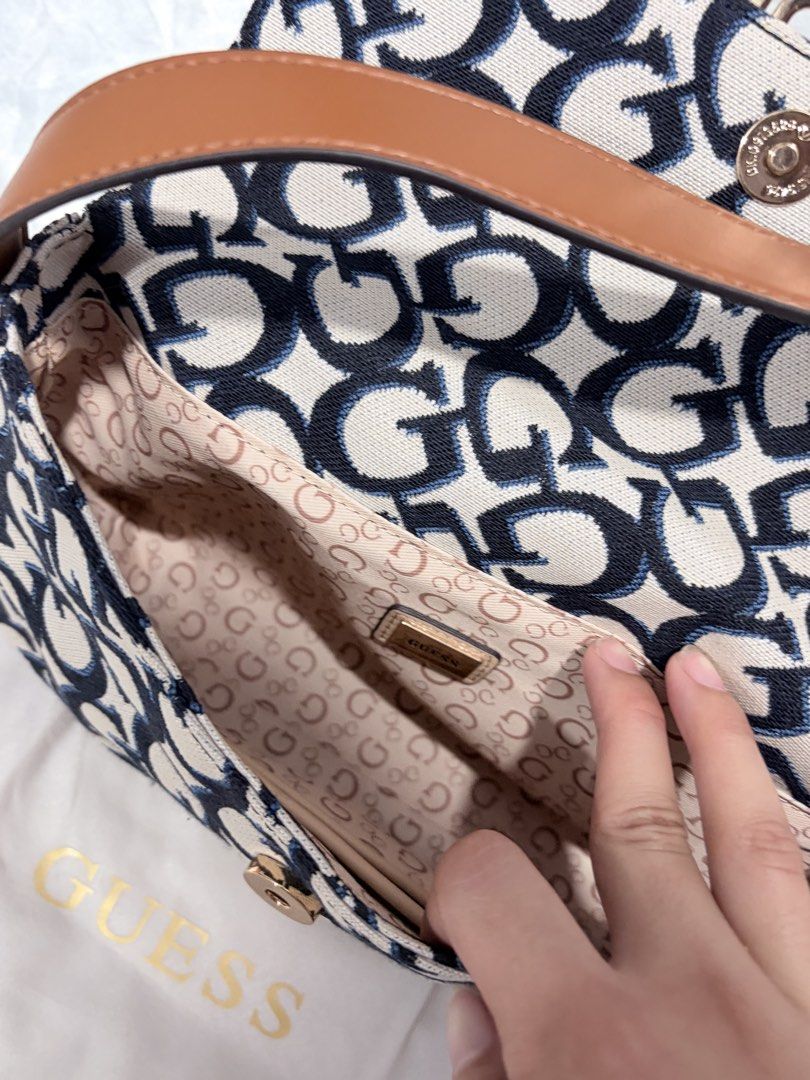 Guess Monogram Shoulder Bag (Category: Luxury Bags & Wallets) located in Quezon City. Submitted by liacleofas (Listing ID 1463330340, Image 2). Description: - Classic Guess monogram shoulder bag - Signature G pattern in navy and white - Tan strap and gold hardware - Interior zip pocket - Guess logo lining - Great for everyday use.