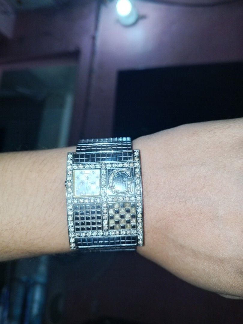 Guess Watch with Rhinestones (Category: Women's Watches) located in Manila. Submitted by itsnotmekhatty (Listing ID 1463404314, Image 1). Description: - Elegant silver Guess watch - Features a prominent large 'G' logo - Adorned with sparkling rhinestones around the face and band - Back details: 'GUESSWATCHES.COM' and 'JAPAN MOV'T' - A chic and fashionable accessory.