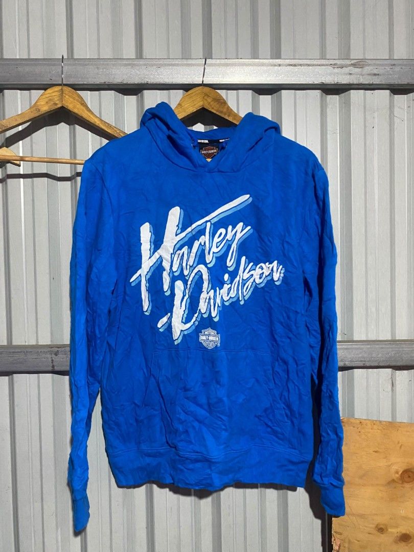 Harley-Davidson Blue Graphic Hoodie (Category: Coats, Jackets and Outerwear) located in Bacolod City. Submitted by carlo1019 (Listing ID 1463481814, Image 1). Description: - Blue Harley-Davidson hoodie - Features classic script logo across chest - Front pocket - Hood with drawstrings - Perfect for casual wear - Shows some signs of wear.