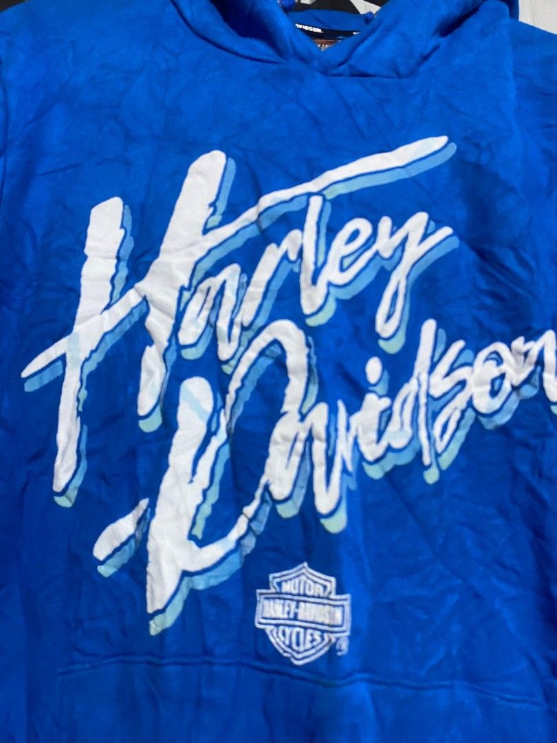 Harley-Davidson Blue Graphic Hoodie (Category: Coats, Jackets and Outerwear) located in Bacolod City. Submitted by carlo1019 (Listing ID 1463481814, Image 2). Description: - Blue Harley-Davidson hoodie - Features classic script logo across chest - Front pocket - Hood with drawstrings - Perfect for casual wear - Shows some signs of wear.