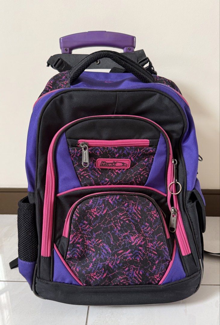 Hawk Rolling Backpack Purple Black Pink Wheels Trolley Bag (Category: Backpacks) located in Quezon City. Submitted by schnauzee35 (Listing ID 1463364518, Image 1). Description: - Cool rolling backpack for school or travel. - Stylish purple, black, and pink design. - Equipped with wheels and a retractable handle for effortless carrying. - Multiple zippered compartments to keep your belongings organized. - Convenient side mesh pockets for water bot