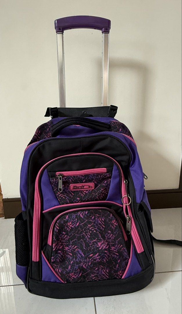 Hawk Rolling Backpack Purple Black Pink Wheels Trolley Bag (Category: Backpacks) located in Quezon City. Submitted by schnauzee35 (Listing ID 1463364518, Image 2). Description: - Cool rolling backpack for school or travel. - Stylish purple, black, and pink design. - Equipped with wheels and a retractable handle for effortless carrying. - Multiple zippered compartments to keep your belongings organized. - Convenient side mesh pockets for water bot