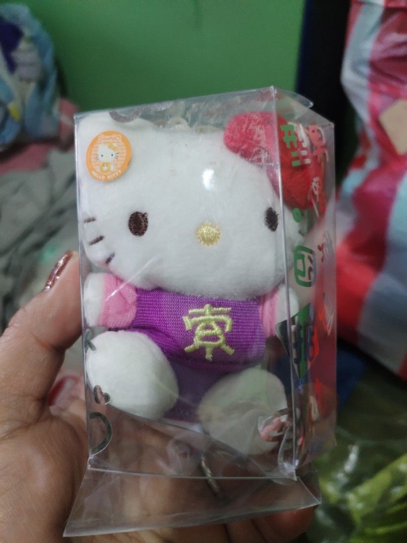 Hello Kitty Plush Keychain with Japanese Character (Category: Plushies & Soft Toys) located in Manila. Submitted by malditas (Listing ID 1463552530, Image 1). Description: - Adorable Kitty plush keychain - Features a cute purple top with Japanese character - Comes in its original clear packaging - Ideal for Kitty collectors - Makes a charming accessory for bags or keys From HT box BUY AS IS (NO RETURN, NO EXCHANGE, NO REFUND unless stated) LOCATI