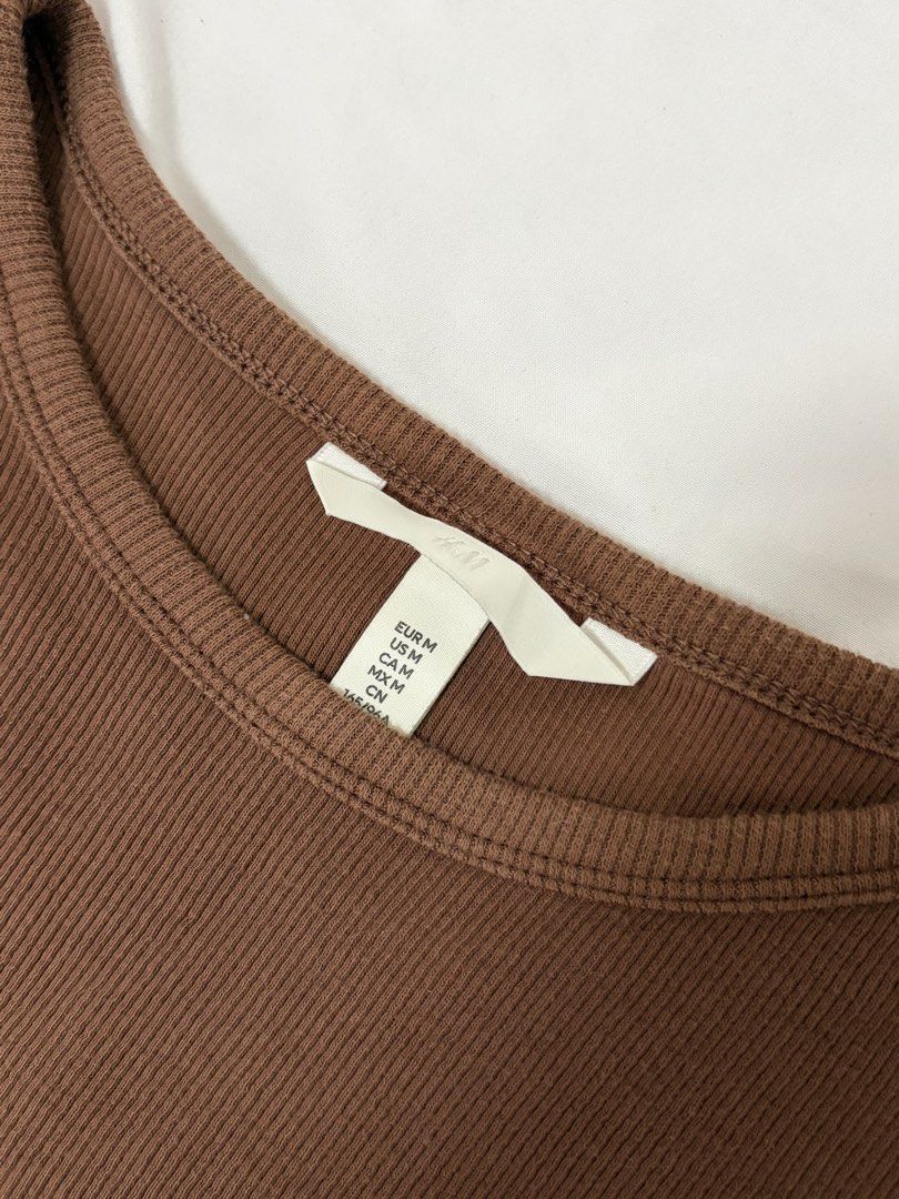 H&M Ribbed Brown Crop Tank Top (Category: Sleeveless) located in Las Pinas. Submitted by thriftedfinds_ (Listing ID 1463492859, Image 2). Description: - Brand: H&M - Style: Ribbed crop tank top - Design: Sleeveless with racerback - Material: Comfortable and stretchy - Versatile: Great for layering or wearing solo - Pairing: Easy to match with jeans or shorts.