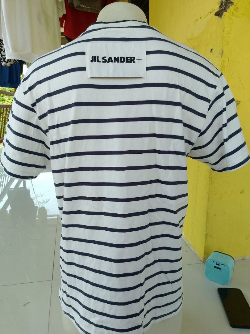 Jil Sander+ Striped T-Shirt (Category: Tshirts & Polo Shirts ) located in Cagayan de Oro. Submitted by thrift.lahat.byck (Listing ID 1463484291, Image 1). Description: - Classic Jil Sander+ striped t-shirt - Color: White with navy blue stripes - Features: Crew neck, short sleeves - Style: Comfortable and stylish, ideal for casual wear - Versatile: Pairs well with jeans or shorts.