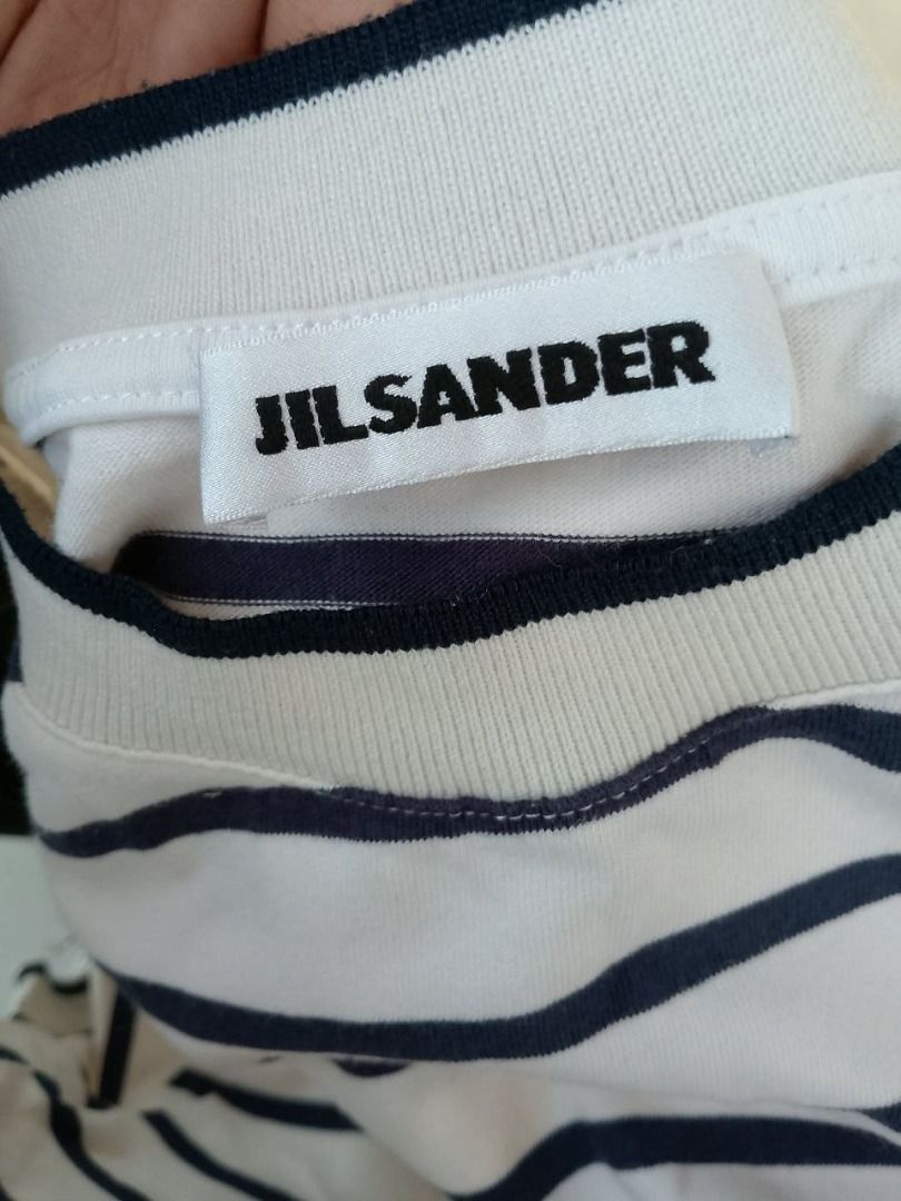 Jil Sander+ Striped T-Shirt (Category: Tshirts & Polo Shirts ) located in Cagayan de Oro. Submitted by thrift.lahat.byck (Listing ID 1463484291, Image 3). Description: - Classic Jil Sander+ striped t-shirt - Color: White with navy blue stripes - Features: Crew neck, short sleeves - Style: Comfortable and stylish, ideal for casual wear - Versatile: Pairs well with jeans or shorts.