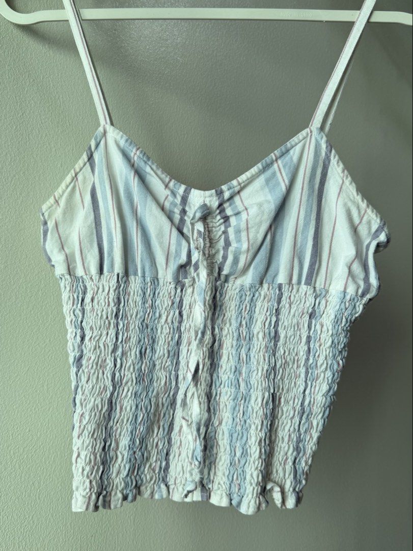 Just Jeans Striped Smocked Crop Top (Category: Sleeveless) located in Caloocan City. Submitted by favestop (Listing ID 1463459253, Image 1). Description: - firs XS-S - Smocked bodice with button-up front - Thin spaghetti straps - Blue, white, and pink stripe pattern - Versatile for casual or dressed-up outfits.