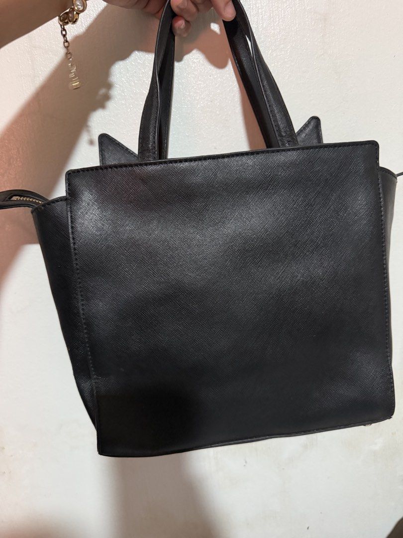 Kate Spade Black Cat Face Tote Bag (Category: Tote Bags) located in San Pablo. Submitted by prelovedbymistyblue (Listing ID 1463387237, Image 2). Description: - Cute black Kate Spade tote bag - Features playful pink cat ears and whiskers detail - Secure top zip closure - Sturdy and reliable handles - Spacious interior for all your essentials - Ideal for everyday use or as a unique statement piece With sling slot but no strap included, with rubber