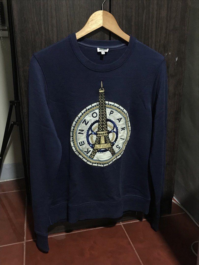 Kenzo Paris Eiffel Tower Sweatshirt (navy) (Category: Hoodies) located in Bulacan. Submitted by dailybumps (Listing ID 1463401089, Image 2). Description: 20x26 Authentic No issue No fade Embroidered Design A classic Kenzo Eiffel Tower Paris Sweatshirt in navy blue, featuring an embroidered graphic of the Eiffel Tower inside a circular “Kenzo Paris” logo emblem.