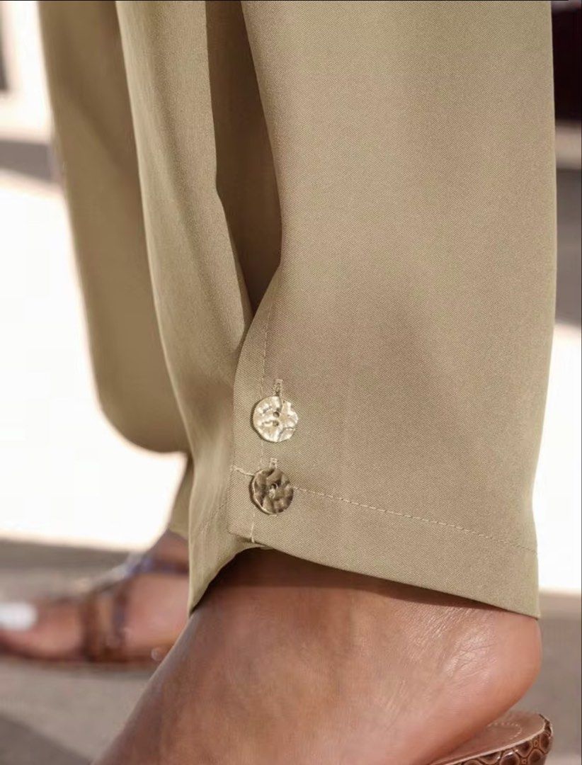 Khaki Barrel Pants with Button Detail (Category: Other Bottoms) located in Villasis. Submitted by juliaxgamboa (Listing ID 1463529777, Image 2). Description: - Khaki colored pants - Wide leg silhouette - Cinched ankle with two decorative buttons - Lightweight and flowy fabric - Versatile for casual or dressed-up occasions - Easy to style.