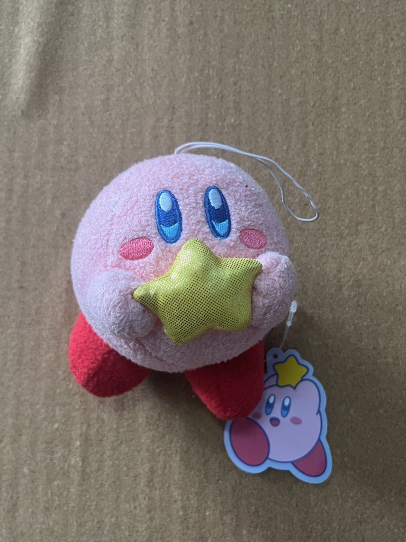 Kirby Plush Toy with Star (Category: Plushies & Soft Toys) located in Baguio. Submitted by gaara1234 (Listing ID 1463350616, Image 1). Description: - Adorable pink Kirby plush toy. - Features a sparkly yellow star. - Includes original tag. - Ideal for Kirby fans and collectors. - Great for display or cuddling..