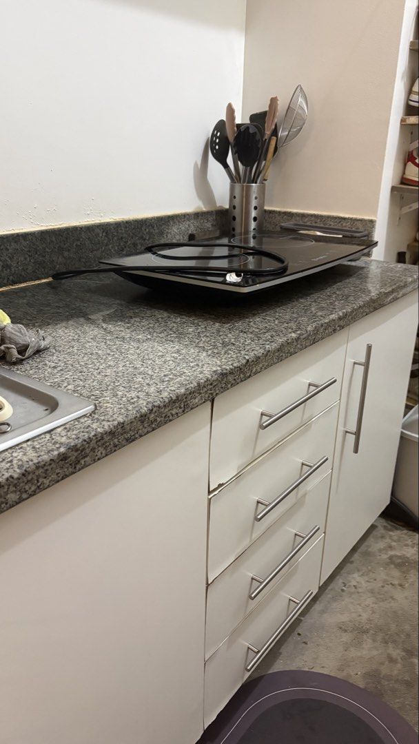 Kitchen Base Cabinets and countertop and backsplash granite (Category: Cookers) located in Mandaluyong City. Submitted by anjie52 (Listing ID 1463368725, Image 2). Description: 180cm L x 60cm W White kitchen base cabinets * Modern, flat-front design * 4 stacked drawers on the left * 1 single-door cabinet on the right * Long horizontal brushed-metal handles * Dark gray/black speckled granite countertop * Matching raised granite backsplash * Standa