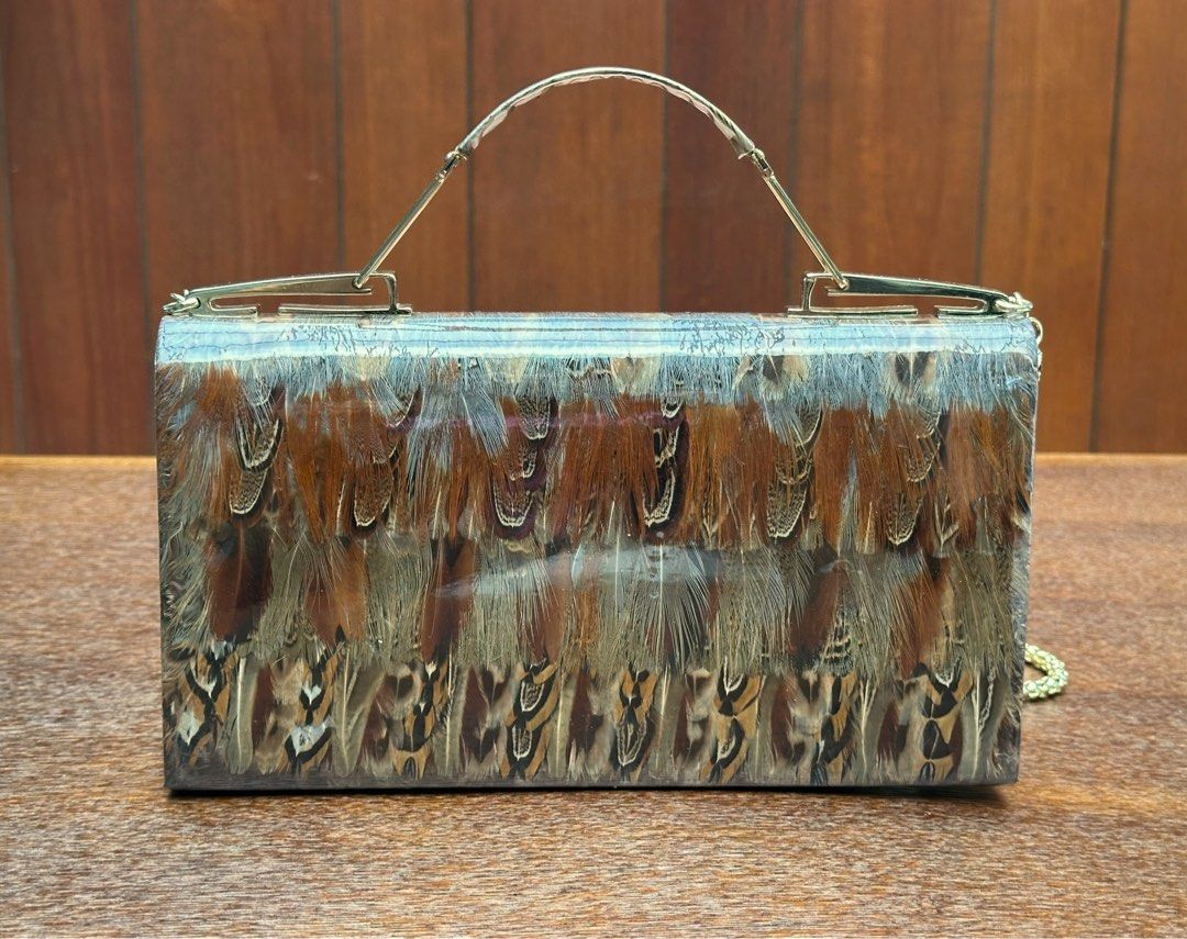 Korean pheasant and peacock feather 2 way (Category: Cross-body Bags) located in Bulacan. Submitted by thriftbagcollections (Listing ID 1463396155, Image 3). Description: This is a vintage 1960s or 1970s Korean pheasant and peacock feather handbag featuring a clear vinyl cover, gold-tone hardware, and a chain strap,with box.Approx:H-6”W-10.2”D-1.5” sling 18.5”.