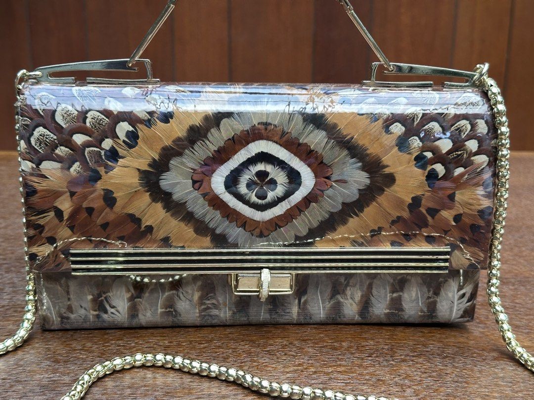 Korean pheasant and peacock feather 2 way (Category: Cross-body Bags) located in Bulacan. Submitted by thriftbagcollections (Listing ID 1463396155, Image 2). Description: This is a vintage 1960s or 1970s Korean pheasant and peacock feather handbag featuring a clear vinyl cover, gold-tone hardware, and a chain strap,with box.Approx:H-6”W-10.2”D-1.5” sling 18.5”.