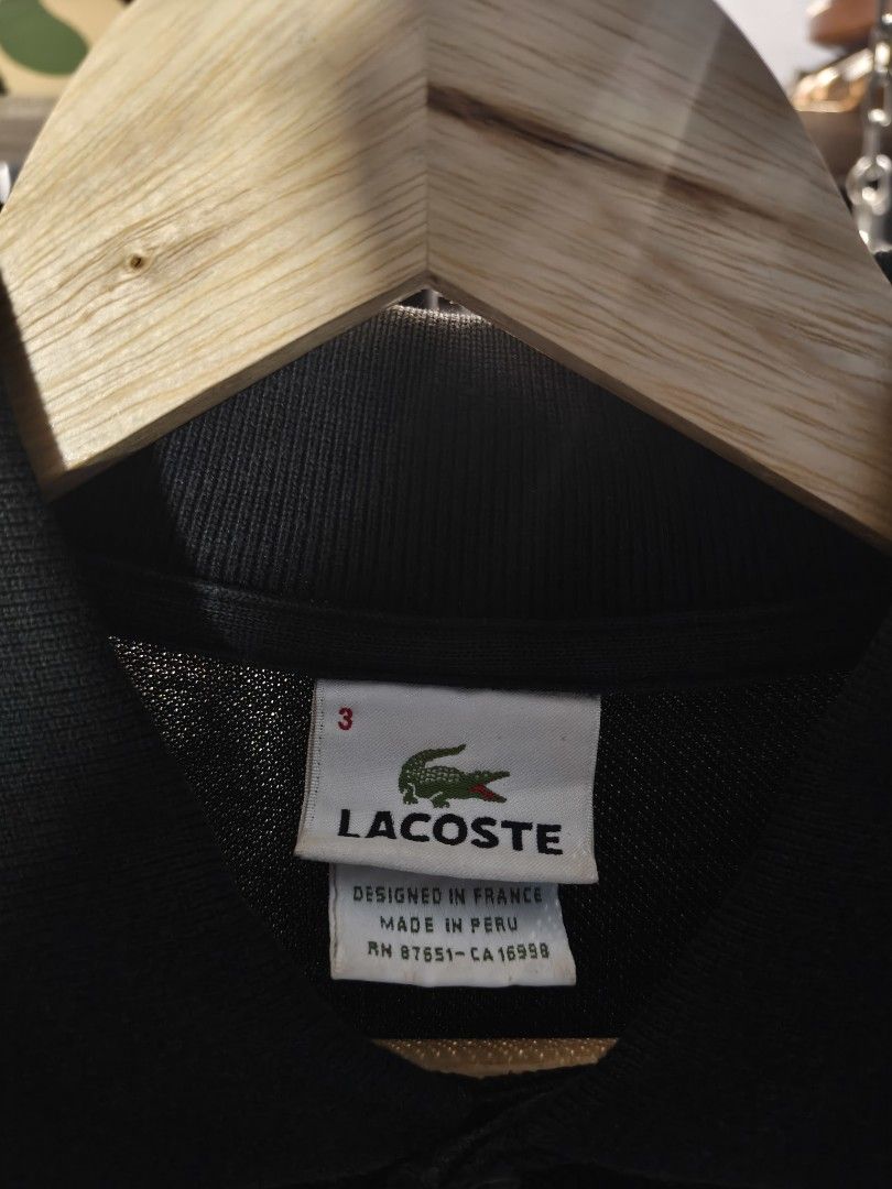 Lacoste Black Polo Shirt Size 3 (Category: Tshirts & Polo Shirts ) located in Aloran. Submitted by ukiyo_goods (Listing ID 1463477026, Image 2). Description: - Classic black Lacoste polo shirt - Features the iconic green crocodile logo - Made in Peru, designed in France - Size: 3 - Versatile for casual or smart-casual wear - Easy to pair with any outfit.