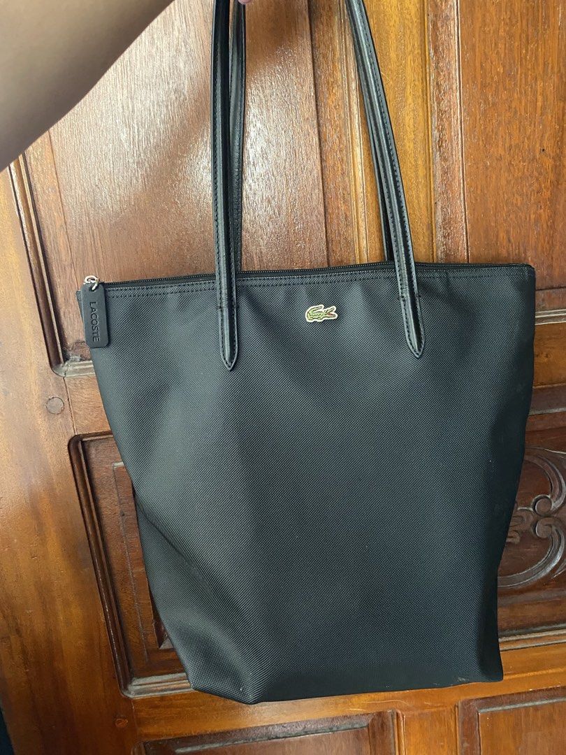 Lacoste Shopper Bag (Category: Tote Bags) located in Pateros City. Submitted by AnnieLam24 (Listing ID 1463464263, Image 3). Description: - Classic black Lacoste tote bag - Durable nylon material - Iconic crocodile logo on the front - Secure zipper closure - Comfortable shoulder straps - Ideal for everyday use or travel - Spacious interior.