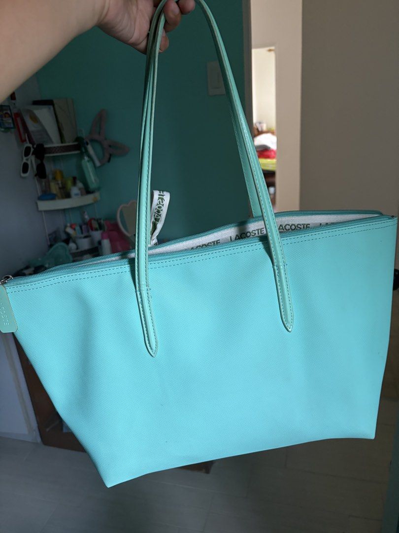Lacoste Turquoise Tote Bag ( COUNTERFEIT ) (Category: Tote Bags) located in Manila. Submitted by amawose (Listing ID 1463350160, Image 2). Description: - Authentic Lacoste turquoise tote bag - Secure zip closure - Signature Lacoste logo on the front - Interior lining with all-over Lacoste print - Two comfortable handles - Ideal for everyday use.