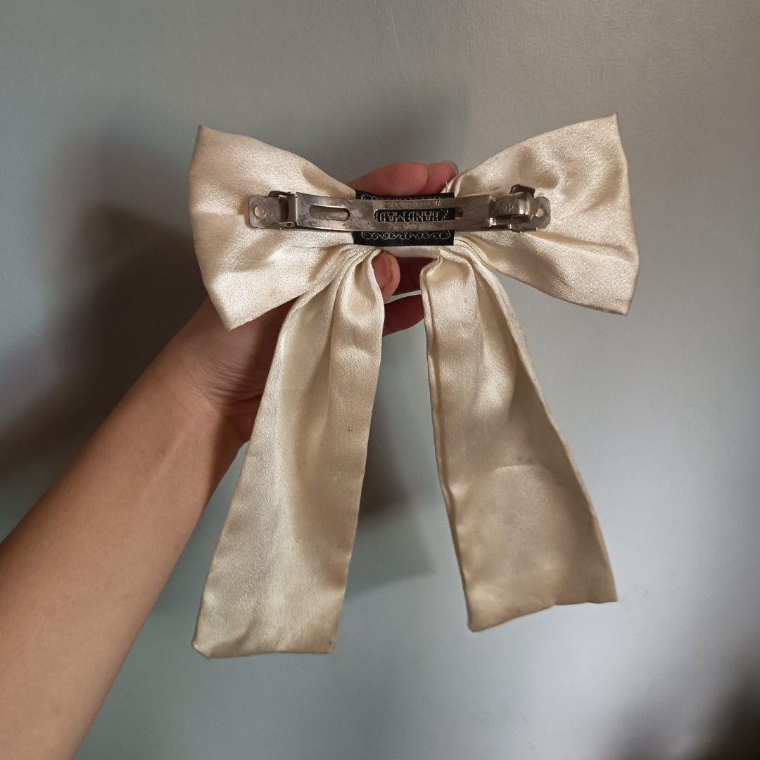 Large Satin Bow Hair Clip Barrette (Category: Hair Accessories) located in Caloocan City. Submitted by cely.777 (Listing ID 1463379127, Image 2). Description: - Big satin bow hair clip - Creamy off-white color - Sturdy metal barrette closure - Adds a statement to any hairstyle - Perfect for casual or dressy occasions - Easy to clip on.