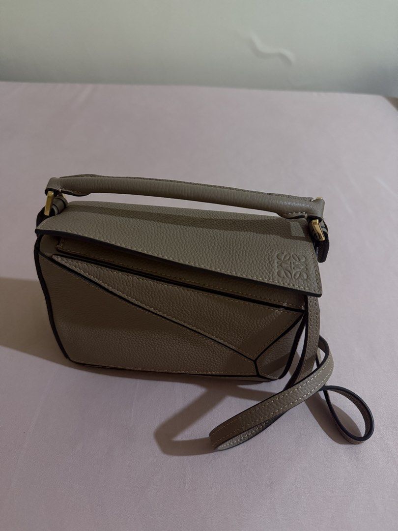 Loewe Puzzle Bag Small Taupe (Category: Luxury Bags & Wallets) located in Manila. Submitted by louisse_iya (Listing ID 1463495563, Image 1). Description: STILL NEGOTIABLE - Color: Taupe - Size: Mini - Hardware: Gold - Features: Detachable shoulder strap - Versatility: Can be carried by hand or worn crossbody.