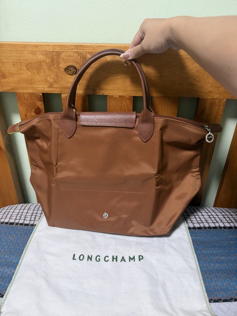 Longchamp Cognac Medium (Category: Luxury Bags & Wallets) located in Las Pinas. Submitted by norlsss (Listing ID 1463472096, Image 3). Description: - Longchamp Le Pliage top-handle bag featuring short leather handles and the signature fold-over flap with a snap closure. - Comes with a dustbag RFS: decluttering.