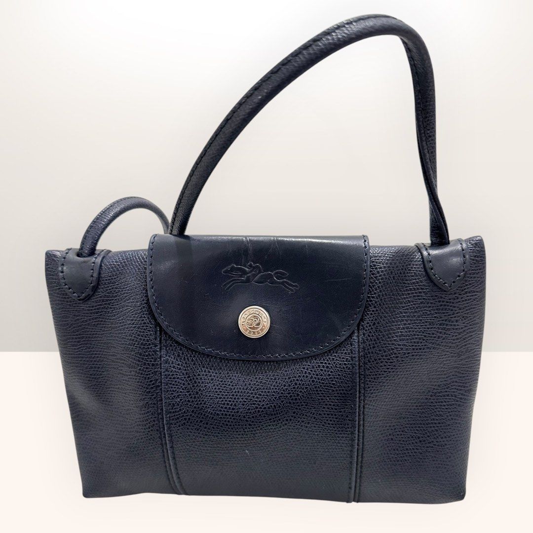 Longchamp Paris Leather Handbag (Category: Luxury Bags & Wallets) located in Bulacan. Submitted by adoseofluxxee (Listing ID 1463505915, Image 1). Description: - Navy blue Longchamp Paris handbag - Made of textured leather - Zip closure with logo flap - Interior zip pocket.